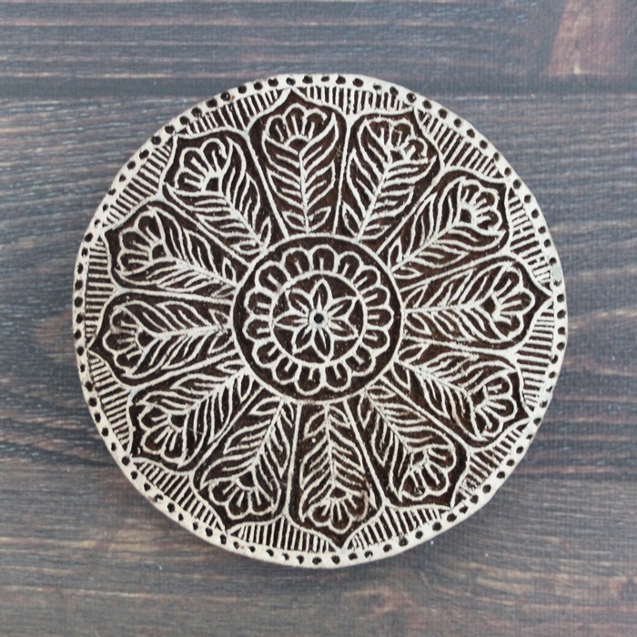 インドの木版。まるい形の中に、花の模様が丁寧に彫られています