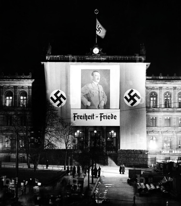 March 27, 1936: Portraits of the Führer are raised on official buildings across Berlin. This one at the Potsdamer Railway Station reads "Freedom - Peace"