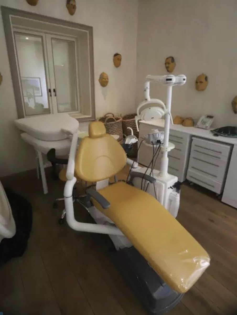 Imagen de la silla de odontólogo utilizada por el espía Jeffrey Epstein, en sus rituales sangrientos contra niños, es parte de los archivos abiertos al público. Nótese la cantidad de máscaras en las paredes, que eran utilizadas por los cómplices del horror para aterrorizar a los