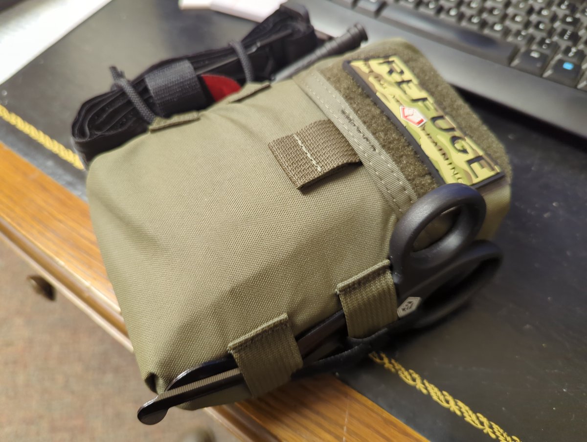 Also on the exterior are serious trauma shears which look like they could cut through a car door. I exaggerate slightly, but they are not cheapos. Stout and razor sharp with a cerrated cutting edge. They come with a helpfu velcro tie down to keep from dislodging on the move 4/