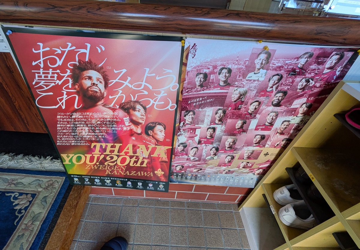 大安の本日、ツエーゲン金沢2026のポスターと後援会の会社玄関に盾を