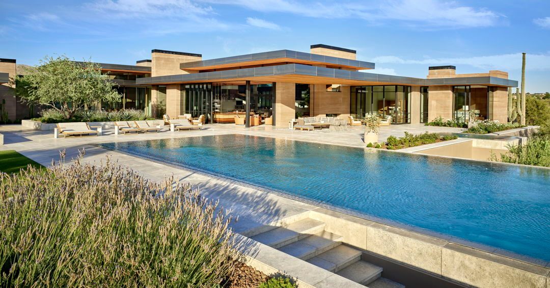 An Olympic-size swimming pool with a Lautner knife-edge—where the water is flush on all sides—adds a clean aesthetic to the outdoor living spaces at this contemporary estate.

To enjoy the entire project, follow the link >> bit.ly/3ZXI5yN
Follow @drewettworks