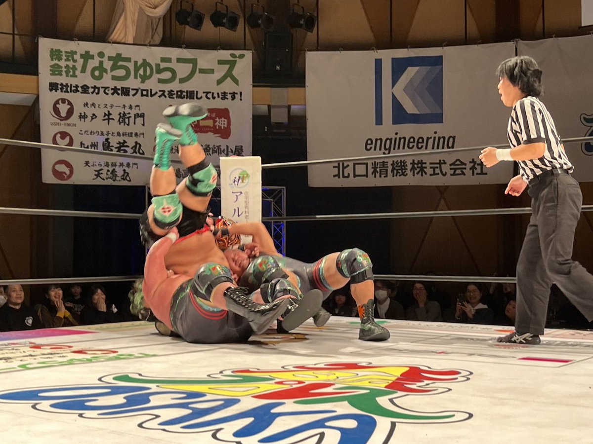 osakapro's tweet photo. コスメフェリーチェ株式会社presents
大阪タッグフェスティバル2026 開幕戦 1回戦

第2試合　30分1本勝負
GAINA＆●HUB
vs
○入江茂弘＆三原一晃
（14分40秒 片エビ固め）

HUB＆GAINAが奇襲。HUBのトペ・スイシーダで一気に主導権を握る。三原をリングに戻し、HUBが徹底的に攻め立てる。
しかし入江＆三原の“ベアーズ”が逆襲。強烈なぶちかましで流れを引き戻すと、入江の重厚なエルボーがHUBを襲う。連携攻撃を浴び、HUBはグロッキー状態に。
それでもHUBが意地のブレンバスターで三原を投げ切ると、GAINAが登場。二人まとめてコーナー圧殺ラリアット。さらにパワーボムを狙うが、三原が切り返しエルボー合戦へ。場内どよめき。
HUBと入江が向き合うと、HUBが複雑な関��技で捕獲。
ベアーズはブレンバスターでGAINAを投げ、HUBへ叩きつける荒技。
さらに二人がかりの筋肉バスターをHUBに炸裂。
しかしGAINAが救出！HUBがセントーン。そしてHUBはラリアットで入江を倒すと、追撃のスプラッシュを放つ。
だが、これを入江が巧みに切り返し——。
入江茂弘＆三原一晃が2回戦進出。

#大阪プロレス