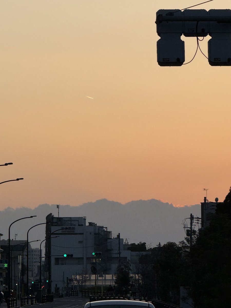 西の空は雲が広がり、普段は見える山も見えず。雲の上に夕焼けが広がっ