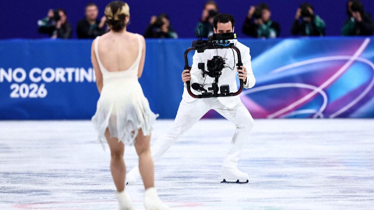 L'uomo in bianco con la telecamera in mano è Jordan Cowan, ex danzatore su ghiaccio statunitense e oggi videomaker professionista.
È anche grazie a lui che abbiamo potuto avere delle riprese pazzesche durante le gare di pattinaggio su ghiaccio 🤩