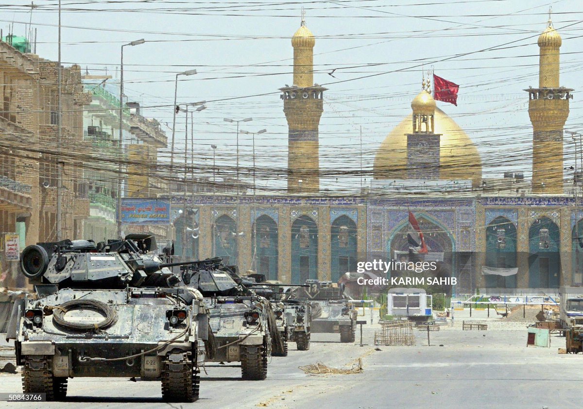 Column of 5 Bradley IFVs driving on a main road in front of the Imam Husayn Shrine in Karbala, Iraq on the 16th of May 2004.