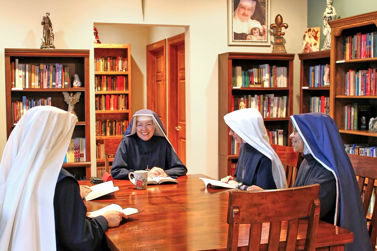 Religious Sisters of the Seraphic Adorers of the Child Jesus in Plover, Wisconsin holding books during a study group discussion. Photo from the Sisters' website at seraphicadorers.com/works/photo-ga….