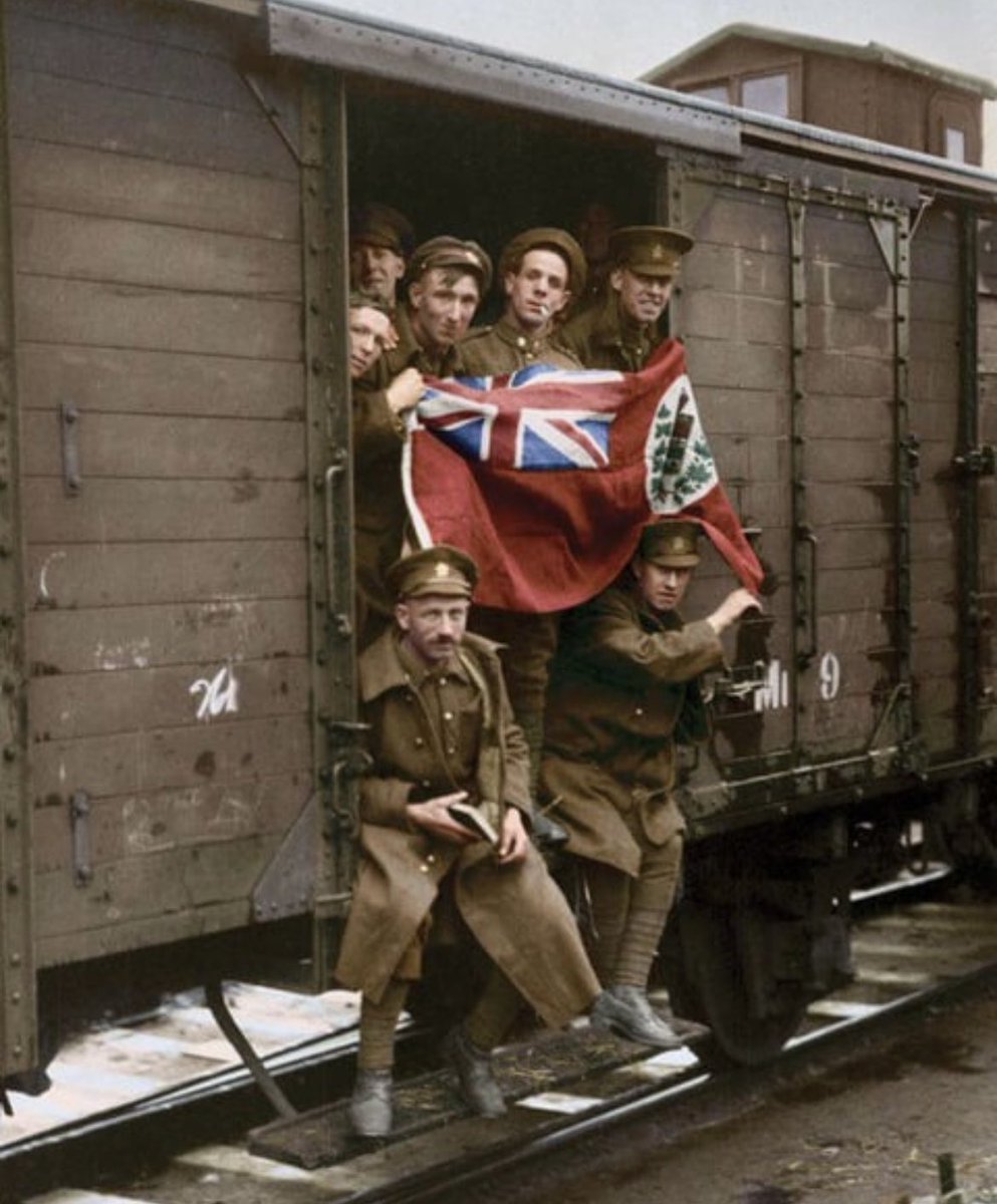 Soldiers of the Canadian 1st Battalion wave the Red Ensign as their train leaves Huy, Belgium (1919)