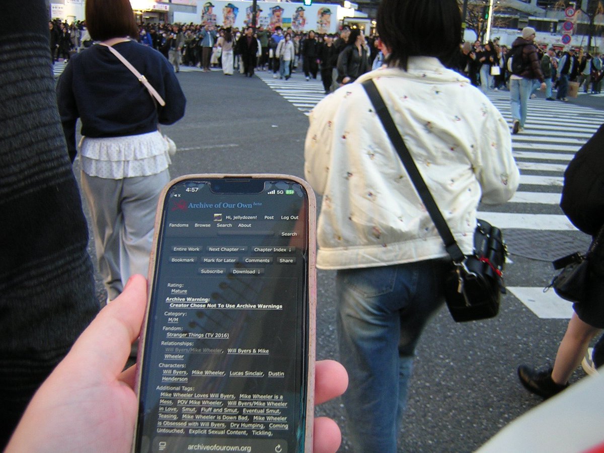 jealousdozen's tweet photo. reading lawless byler at shibuya crossing https://t.co/s86XVfQ4Dm