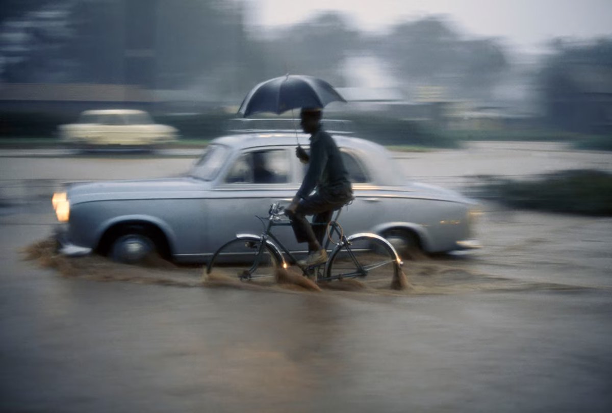 A torrential downpour doesn't stop traffic in Nairobi. Kenya, 1969 | Bruce Dale