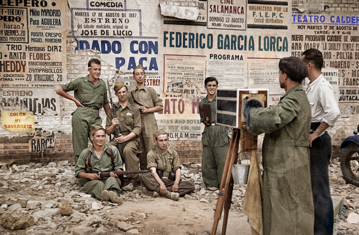 historiacolor's tweet photo. Una de las fotos más pintorescas de la guerra civil en Madrid. Era el año 1937. Llevábamos ya un año de guerra. Un fotógrafo minutero hace una fotografía a un grupo de soldados delante de una pared plagada de cartelería de otros tiempos. https://t.co/xXY3bMvoqf