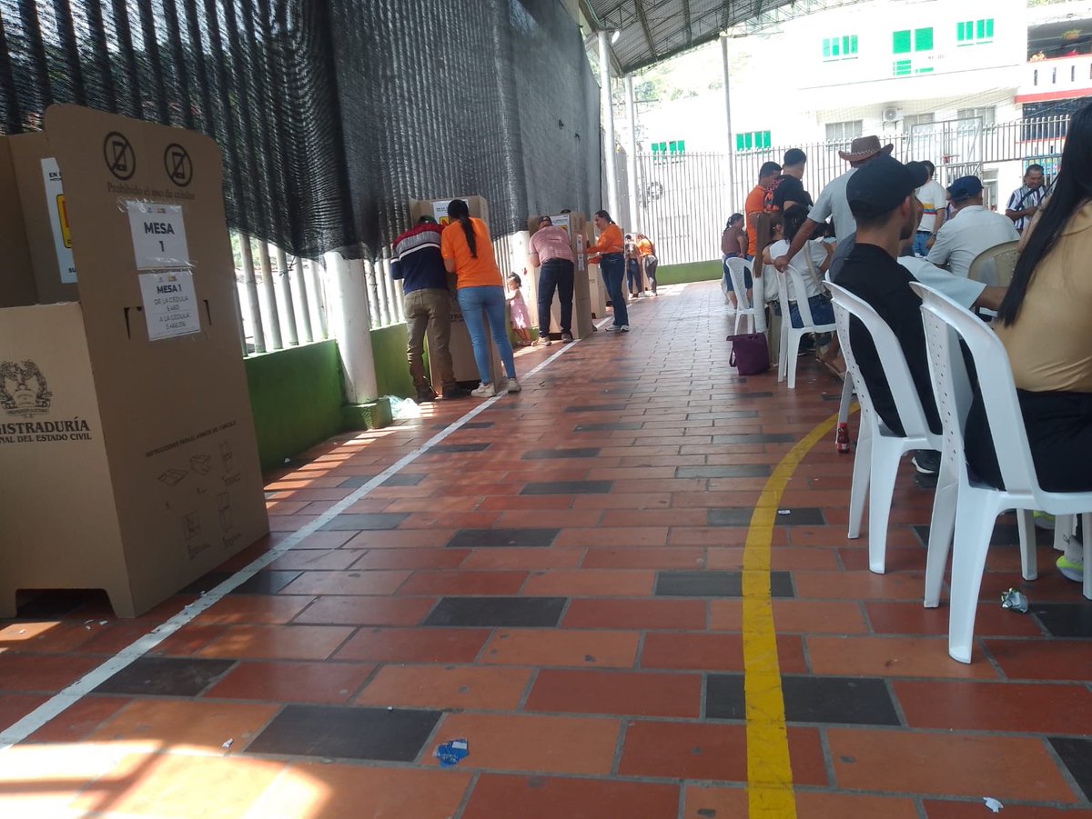 YoAlejoV's tweet photo. En Ábrego, Norte de Santander, personas con camisetas naranja, referencia de un candidato, ayudándole a votar a la gente. También hay gorras dentro de las mesas con logo y número. ¿Qué es esto? @Registraduria @FiscaliaCol

En el pueblo esos candidatos hacen lo que se les da la gana.