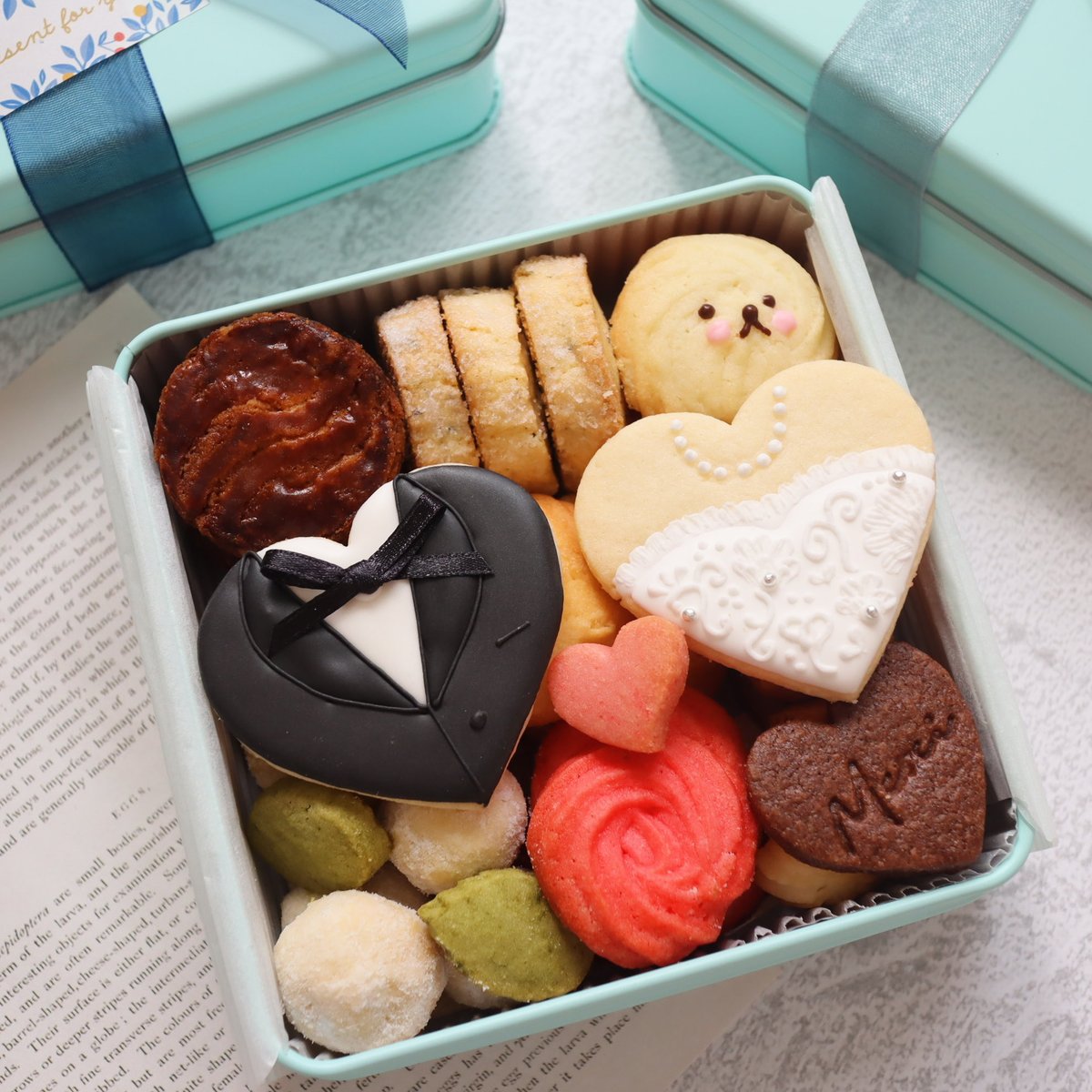 UmaiTakei's tweet photo. 結婚式の引出物用に作った想い出のクッキー缶💍

当日に着たドレスをデザインしたアイシングクッキーと義実家の飼い犬の絞り出しクッキーがお気に入り🥰

#クッキー缶に魅せられて #cottaフォトコンテスト https://t.co/9qQPs5x1Lg