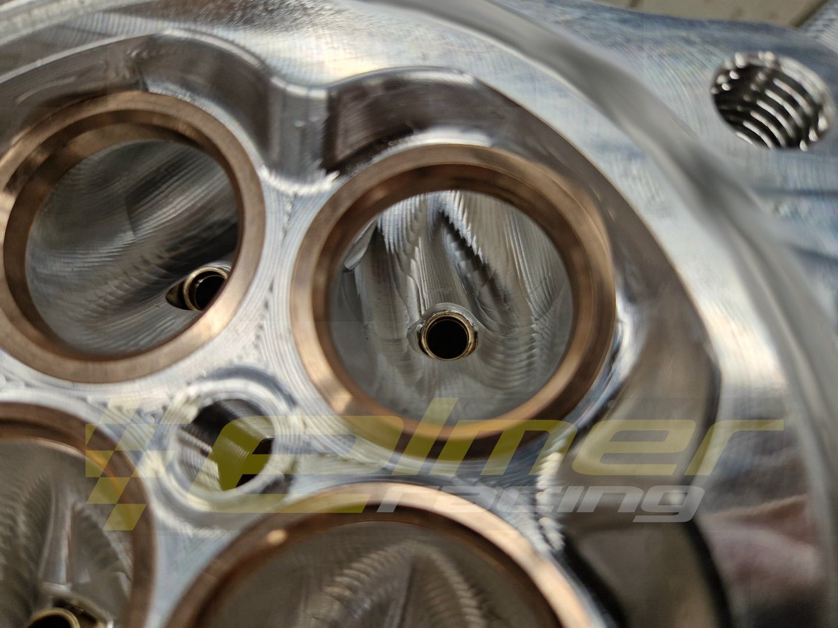 ElmerRacing's tweet photo. Close up look at how hard the design is pushed on our 4000hp Hel engine.
Intake and exhaust valve guides are fully integrated into the port design. And the port cross section area fully takes this shape into account.
The exhaust value guides have a shorter external end taper and different internal diameter for the tip to reduce the temperature of the tip. But still needs to be very close to the valve head to get good heat conduction and valve cooling.
Intake side is fully contoured behind the valve guide hump to reduce turbulence.
At full power both the intake and exhaust flow is mach limited during the entire valve open period. Shapes and maintaining port cross section really matter to help reduce shock waves and port flow losses close to the valve.