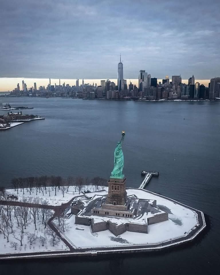 Buenas noches, descansen y disfruten de un feliz sueño. Bellísimo atardecer con vista a la Estatua de La Libertad, en la bahía de la ciudad de Nueva York al fondo, EE.UU. "Maravillas Del Mundo".