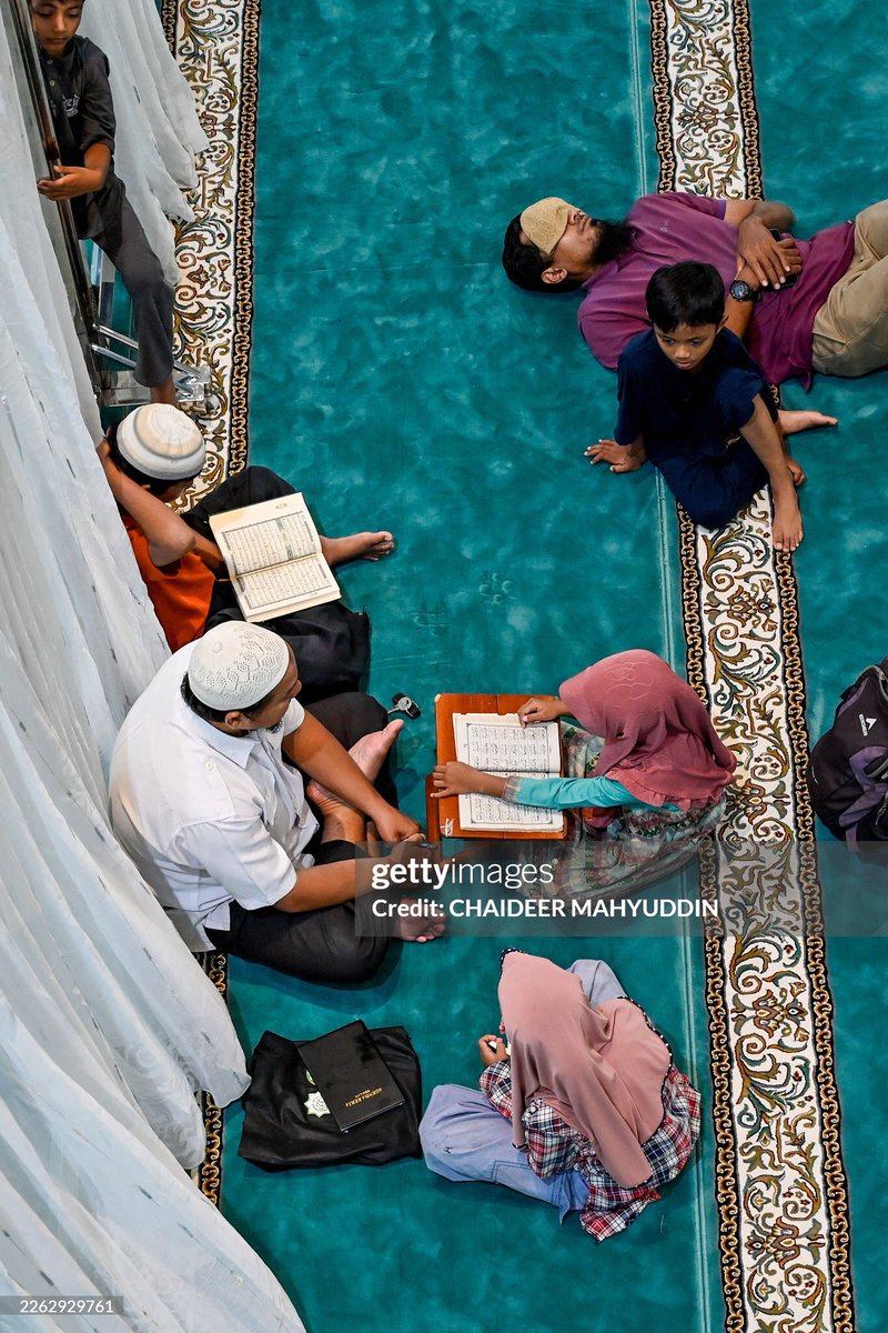 Iqbal_langdon's tweet photo. Sejumlah pria beristirahat sementara beberapa lainnya membaca Al-Qur'an setelah salat zuhur berjamaah di Masjid Oman Al-Makmur selama bulan suci Ramadan di Banda Aceh pada 25 Februari 2026. Foto: CHAIDEER MAHYUDDIN / AFP https://t.co/uEUNno2Ucm