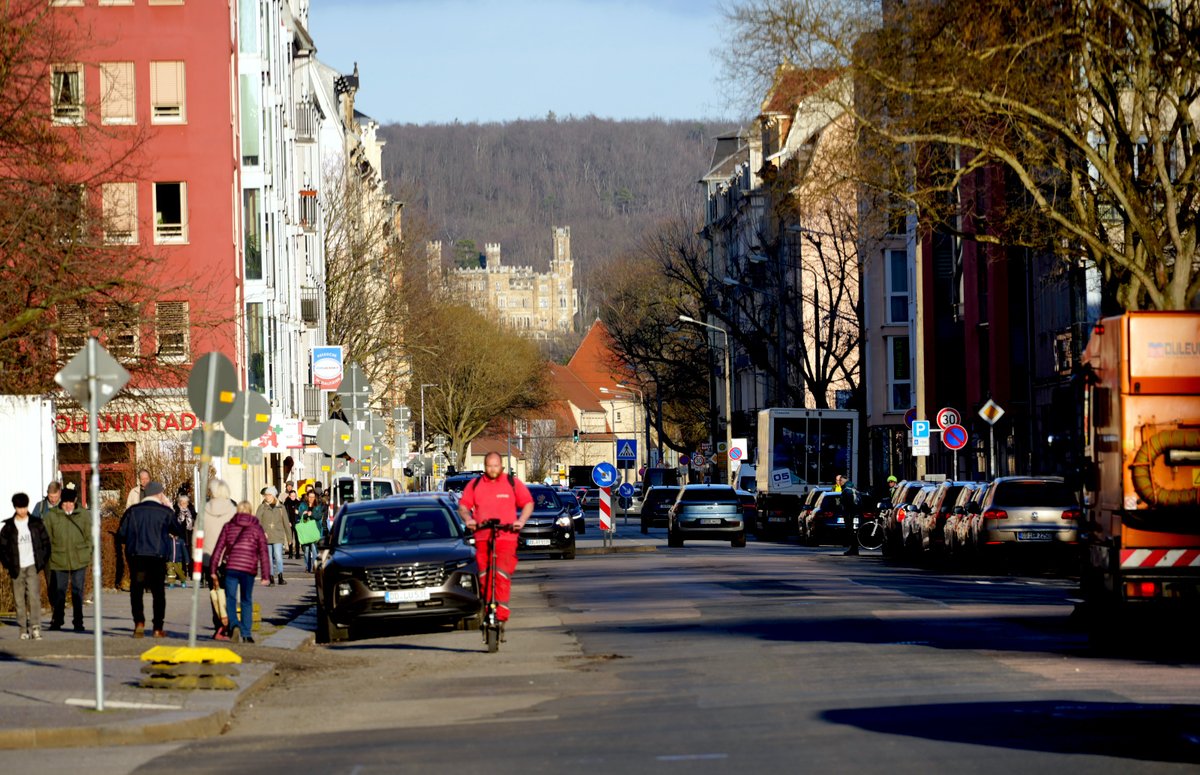 Forstler1's tweet photo. Die Johannstadt von Dresden

Das Viertel entstand Ende des 19. Jahrhunderts auf einem freien Feld vor der Stadt. Es wurde ein ziemlich geschlossenes Viertel mit Straßenzügen im Stile des späten Kaiserreiches. Die Häuserzüge wurden meist rechteckig um einen großen Hof angelegt, in den Höfen wuchs eine reiche Kleinindustrie. Handwerker, Baubetriebe. Es gab viele Geschäfte und Gaststätten. Die zentrale Straße, die Pfotenhauerstraße, wurde nach einem Dresdner Oberbürgermeister benannt.  Sie entwickelte sich schnell zu einer pulsierenden Flaniermeile mit vielen Geschäften und Gaststätten. 1893 wurde eine Straßenbahnlinie in der Straße gebaut, die erste elektrische Straßenbahn Sachsens, vom Theaterplatz zum Blauen Wunder, von der man heute immer noch träumt, sie wieder anzulegen. In dieser Straßenbahnlinie fand 1901 der Mord aus verschmähter Liebe am Komponisten Gustav Adolf Gunkel statt, der sogar literarisch wurde: 

https://t.co/iZzhi1VZoK 

Als man 1876 die Straße anlegte, richtete man sie nach dem 1861 auf der anderen Elbseite errichtete Schloss Eckberg, dem rechten der drei Dresdner Elbschlösser aus. Man hatte damals einen guten Sinn für Blickbeziehungen.

Während des Bombenangriffs von Februar 1945 wurde das Viertel weitgehend zerstört, lediglich am östlichen Ende im Bereich Hertelstraße-Neubertstraße-Blumenstraße stehen noch ein paar originale Häuser. Zu DDR-Zeiten nicht gepflegt und mit schlechter Ausstattung aus der Gründerzeit: Kohleheizung (Einzelöfen), Außen-WC, keine Bäder. Nach der Wende saniert, heute begehrte Altbauwohnungen. Dieses Stadtviertel war der Stadtbezirk Dresdens mit dem höchsten Zerstörungsgrad nach dem Angriff im Februar 1945. 

Zu DDR-Zeiten, anders konnte man es damals wohl nicht, krachte man elfgeschossige Plattenbauten in die Gegend, wobei auch Straßenzüge wie die Blumenstraße überbaut wurden. Nach der Wende begann man, angrenzend an die bestehenden Häuser östlich ein paar Lücken zu schließen. Schön sehen sie auch nicht aus und die Geschäfte in den Erdgeschossen stehen heute oft leer. Und man hat diesen Wiederaufbauprozess wohl beendet, der in der Euphorie der Wendezeit viel großzüger gedacht war. 

Obwohl mittlerweile in der Johannstadt viele Menschen leben, war die Einwohnerzahl vor dem Krieg dreimal so hoch wie heute. Im Bereich der Nördlichen Johannstadt in die Plattenbauten zogen viele Neubürger ein, die mittlerweile das Stadtbild sehr prägen.

Die Bilder sind von gestern, die beiden unteren Bilder habe ich von einer Tafel abfotografiert, die einen historischen Rundgang durch die Johannstadt begleiten. 

(1) Die Pfotenhauerstraße mit Blick auf Schloss Eckberg.

(2) Solchen industriell gefertigten Schmuck sieht man noch an den wenigen verbliebenen Häusern.
 
(3) Auf dem historischen Bild sieht man gut die Straßenbahngleise. Der Standort entspricht nicht dem der neuen Aufnahme oben links, er ist genau einen Straßenzug weiter östlich, hinten.

(4) Das Afrikazimmer im Elsässer Hof in der Pfotenhauerstraße. Damals hatte Deutschland einige Kolonien erworben, Schutzgebiete genannt, Togo, Kamerun, Ostafrika (Tansania), Südwestafrika und ein paar weitere in Asien-Ozeanien. In Deutschland entstanden viele Kolonialwarenläden und solche Gaststätten. Selbst die heutige EDEKA erinnert an diese Zeiten, ging sie doch aus der 1898 gegründeten Einkaufsgenossenschaft der Kolonialwarenhändler hervor.