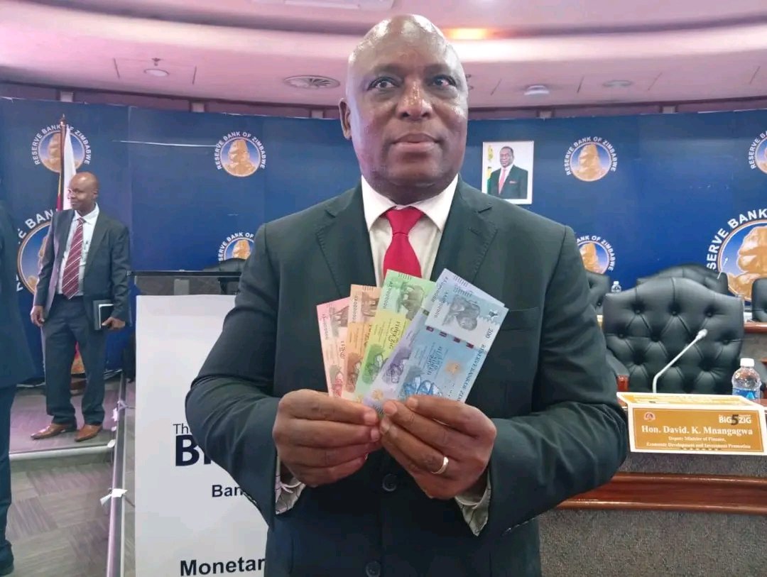 RBZ Governor John Mushayavanhu holding the new notes, 10, 20, 50 and 100, 200