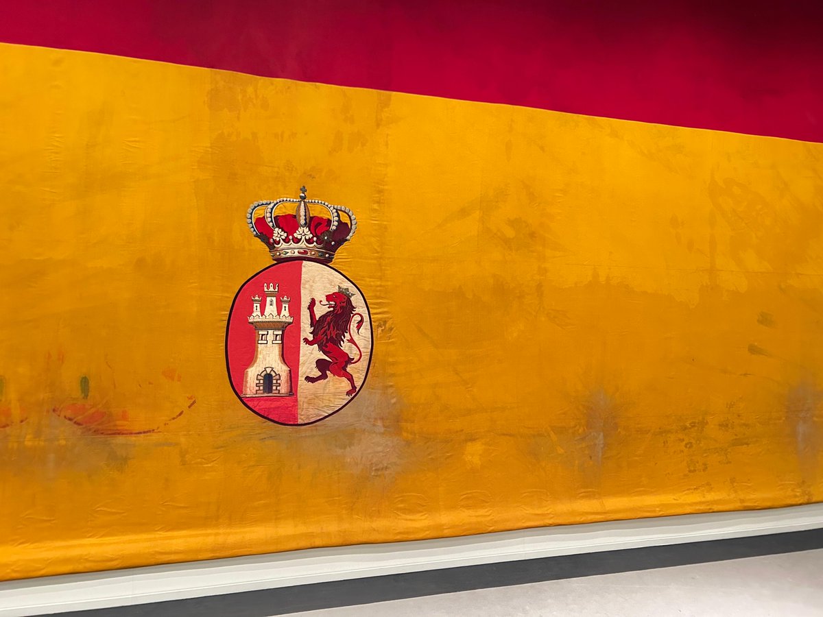 En la expo #LaBanderaqueVinodelaMar podéis ver banderas con escudos bordados.

Algunos son joyas que han llegado hasta nuestros días en bastante buen estado como los que decoran la  bandera de combate del crucero Reina Mercedes 1898, la #bandera más grande de la exposición.