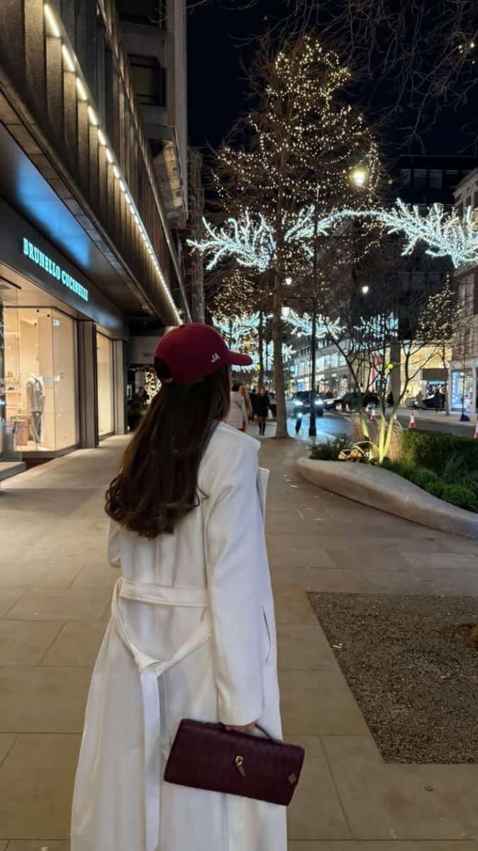 radha2155's tweet photo. Here are some perfect caption and hashtag ideas for your stunning nighttime London luxury street photo! The white coat, red cap with "JA", Brunello Cucinelli storefront, twinkling tree lights, and that festive winter glow scream quiet luxury meets holiday magic in the heart of https://t.co/dXSDRAVW9t