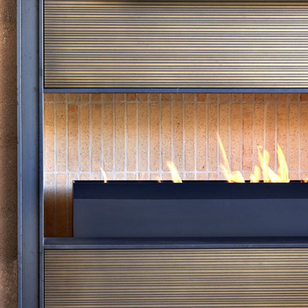 Steel, bronze, rammed earth and a glowing flame provide a rich, layered composition.

To enjoy the entire project, follow the link >> bit.ly/3ZXI5yN
Follow <a href="/drewettworks/">Drewett Works</a> for modernist regionally-inspired architecture. 
🔗 Link in our bio for more DW-designed projects