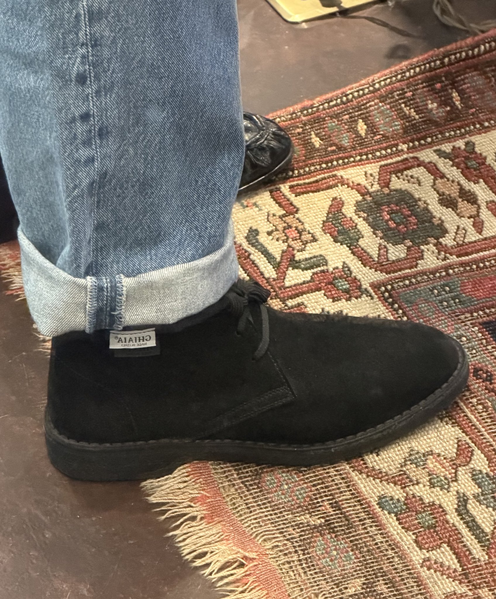 Cuffed loose jeans and suede desert boots with a band of sock showing, posted on X by @jakewoolf