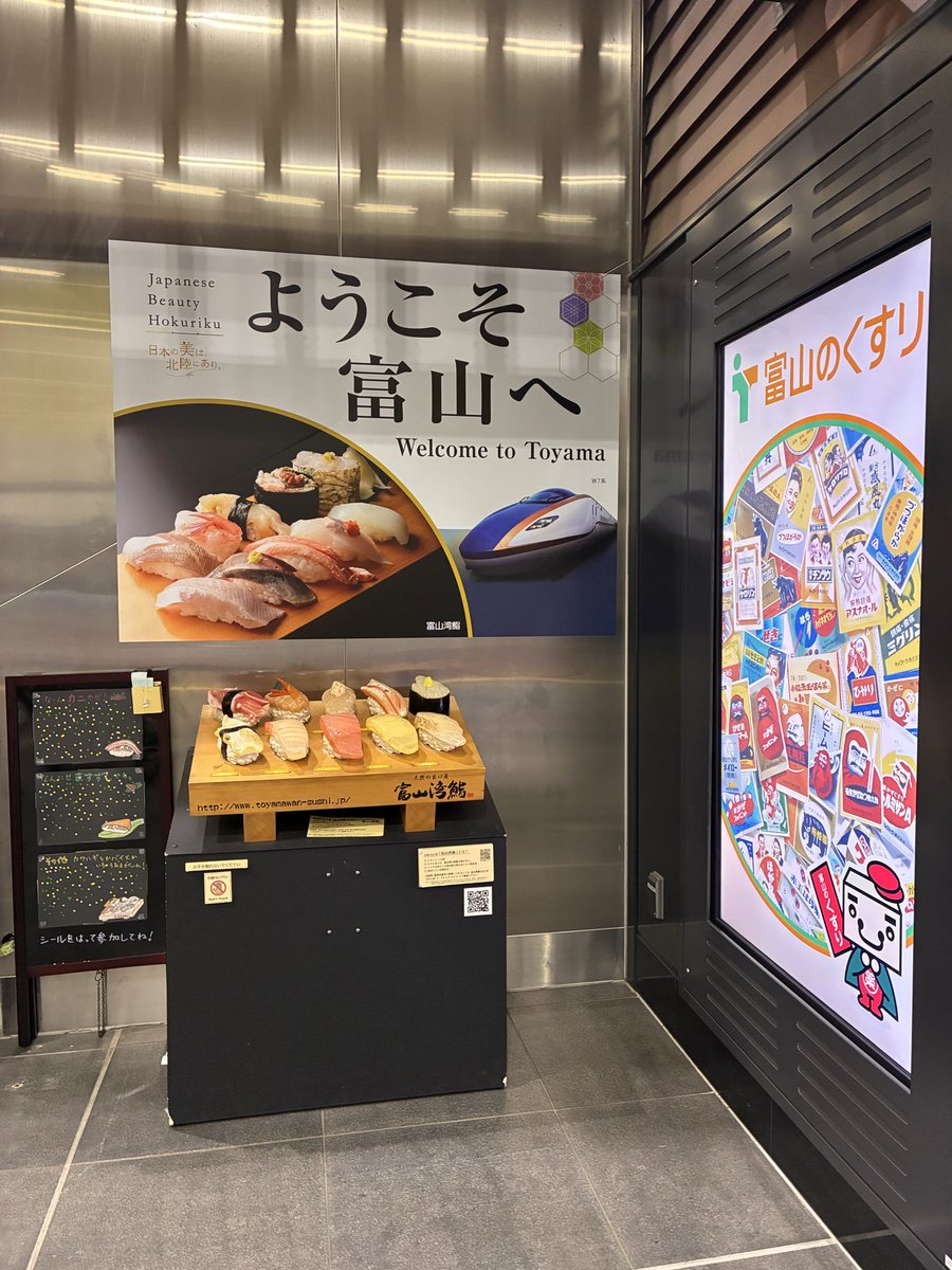 富山駅到着 デカい寿司の模型(財布との比較) ローカルの広告を捕獲