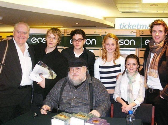 Parte do elenco principal de Game of Thrones conhecendo o autor George R.R. Martin, em 2009, durante as gravações do piloto da série. Maisie Williams (Arya Stark), Sophie Turner (Sansa Stark), Alfie Allen (Theon Greyjoy), Richard Madden (Rob Stark) e Kit Harington (Jon Snow).