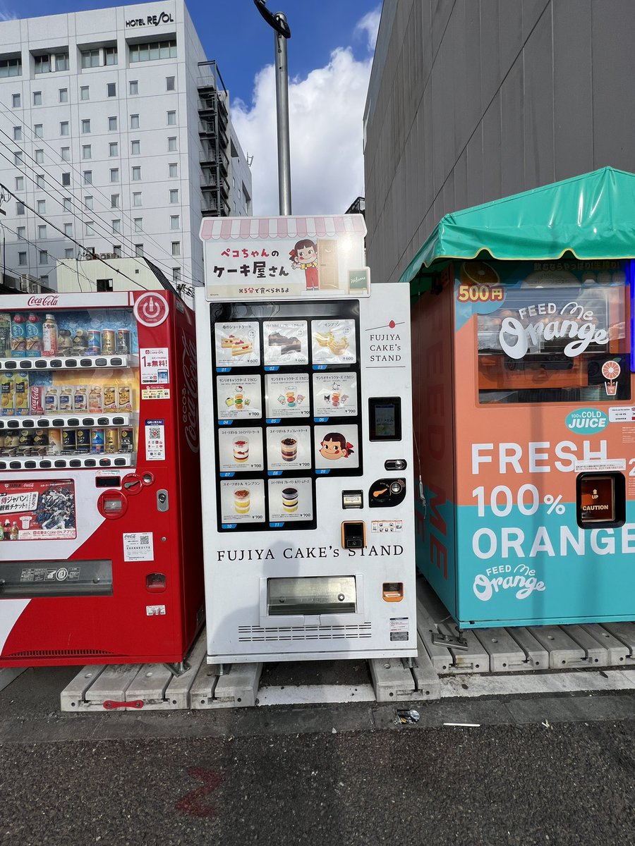 You think a random Fukuoka street walk is boring? Think again! 🍰

Random discovery: Fujiya’s Peko-chan Cake Stand vending frozen treats right on the sidewalk.

Options ¥600-¥700 (chocolate, pudding, more). Pair with the orange juice machine next door for the ultimate combo.