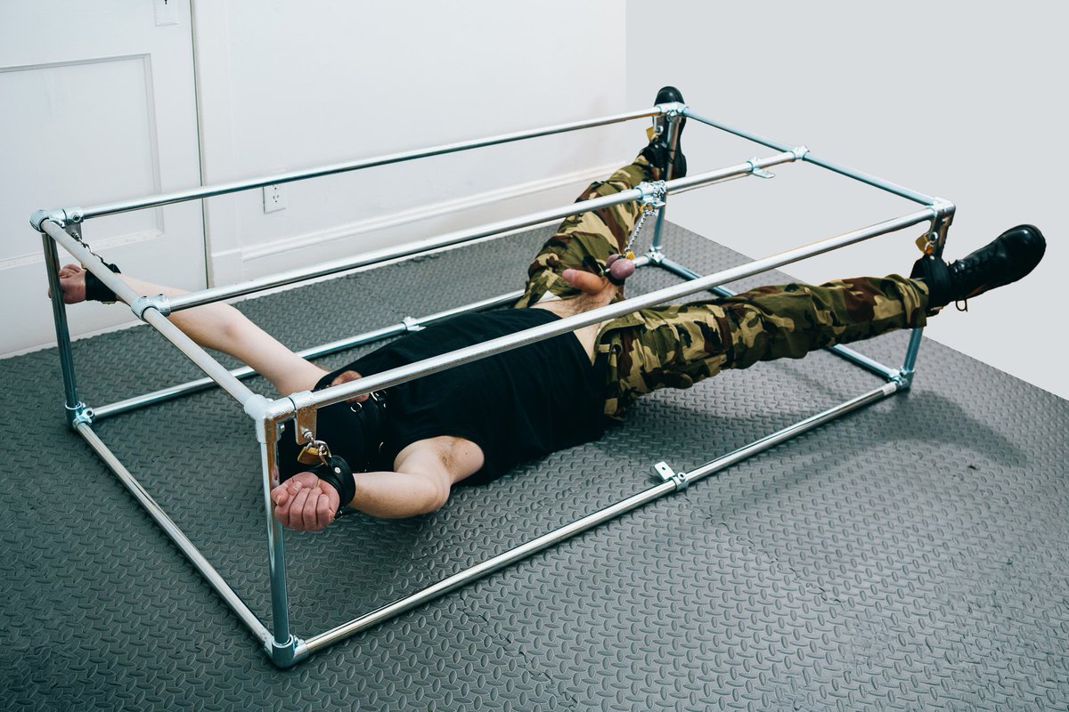 Chained up spread eagle, unable to fully relax with tension on balls.