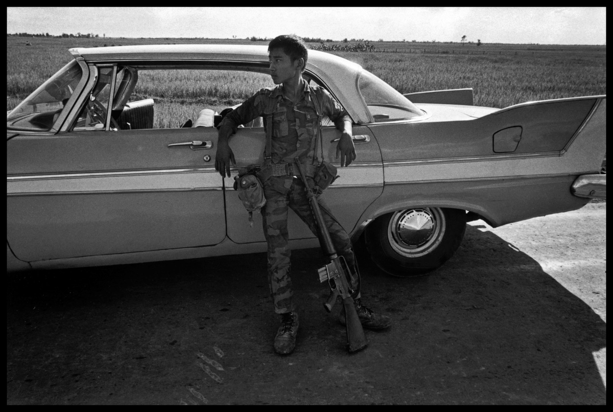 ARVN Soldier resting on a stunning later 1950s 4 door Plymouth Fury in South Vietnam.