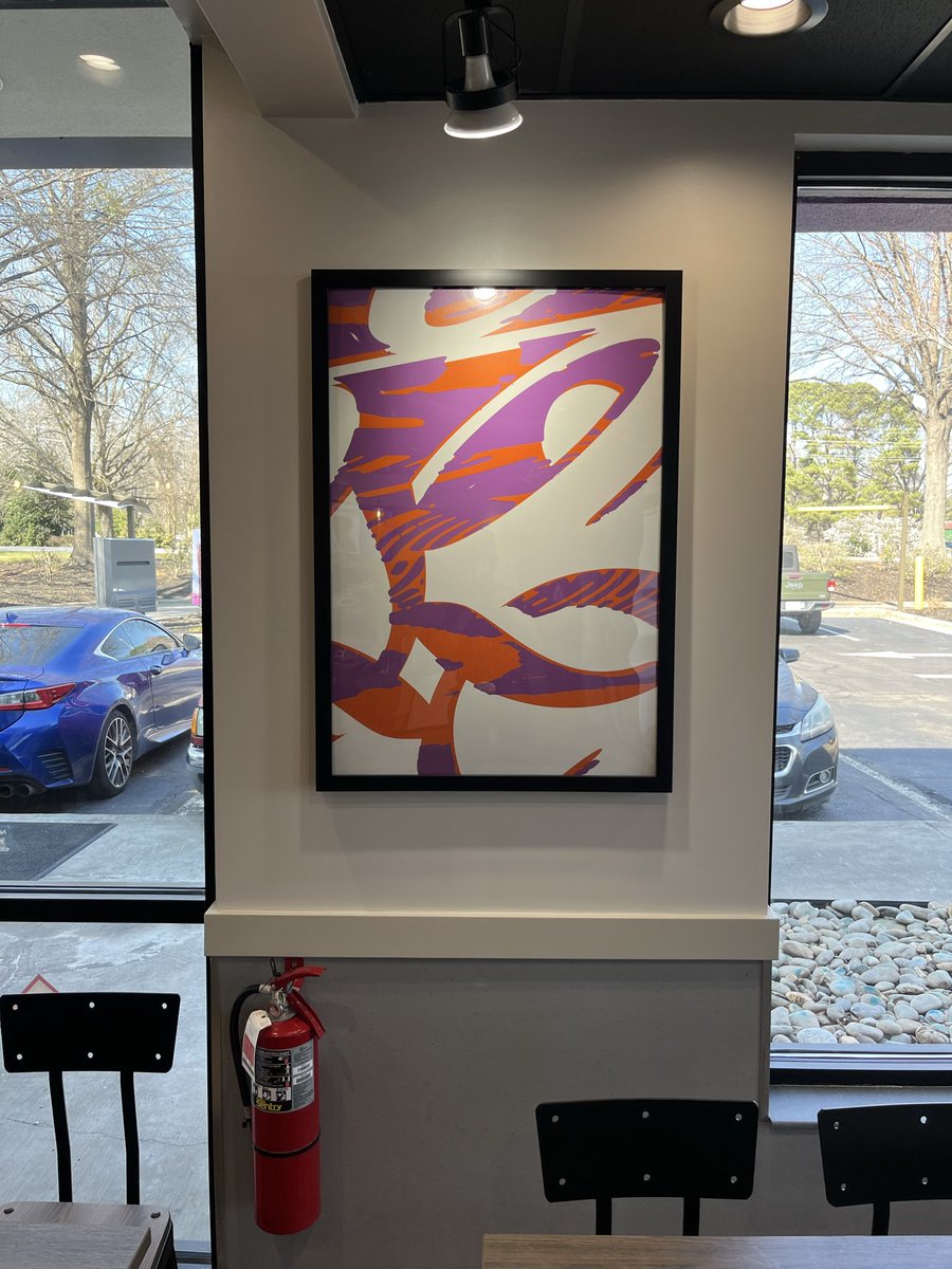 MykkiBlanco's tweet photo. Everything in America is a weird Amazon shell now. This is what’s left of the interior of a Taco Bell, a framed painting denoting a more festive past inside a grayscale soulless box. DAMN https://t.co/yWqCH7lDs5
