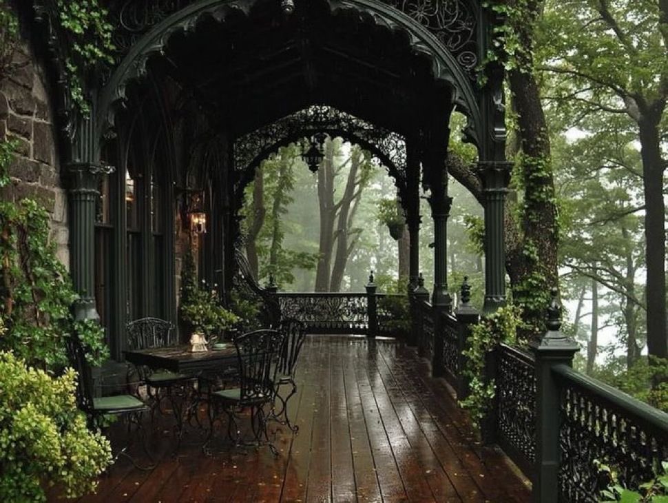 A big front porch surrounded by trees.