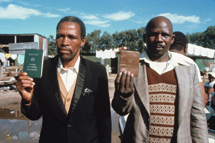 HistorySAZAR's tweet photo. c 1980s: Two men in Crossroads hold up their pass books, also known as dompas. Photo Credit: Margaret Courtney-Clarke https://t.co/nG4bXqFrdK