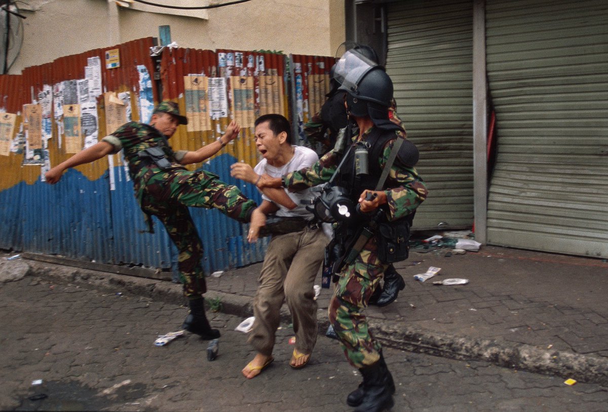 Jakarta, 1 Mei 1998. Seorang tentara tertangkap lensa kamera fotografer Amerika John Stanmeyer tengah menendang perut seorang pria tak dikenal — yang dituduh menjarah toko kaset musik.

Dapat kita lihat, ada 2 tentara lain, seorang di antaranya turut mencengkeram tangan si pria.