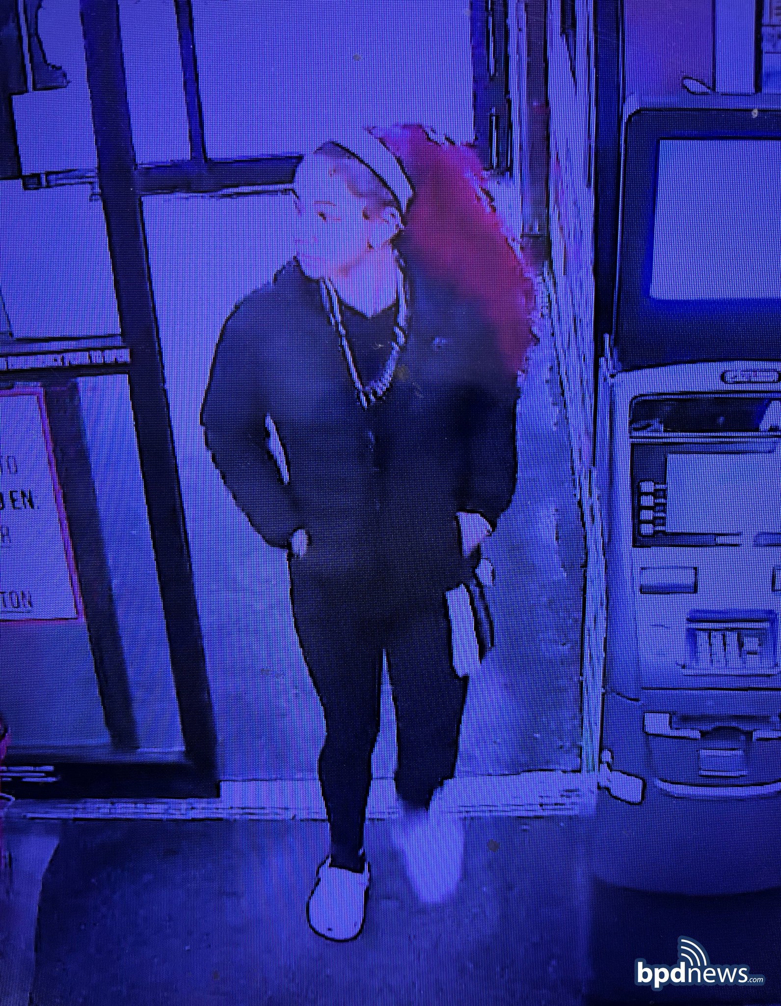 Surveillance image of suspect in face mask and dark clothing