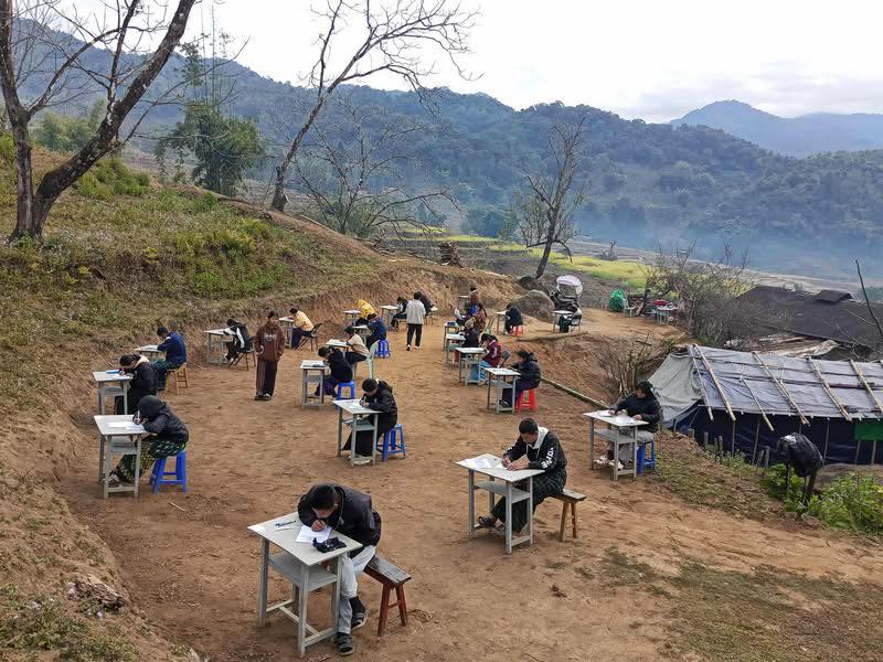 School buildings are unreliable for safety during wartime. The picture below shows students in Myanmar’s Kachin State taking their final exams. The Myanmar military has been bombing villages and towns in the region since the 2021 coup.

Crd: original photographer.