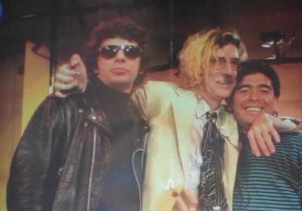Diego10Querido's tweet photo. 1997: Con remera maradoneana, Charly escucha en la galería Bond Strett el tema "Heaven Knows I'm Miserable Now", perteneciente a The Smiths. En la imagen original de la remera estaba Juanse, quien sería recortado. https://t.co/2HD8w3lzGC