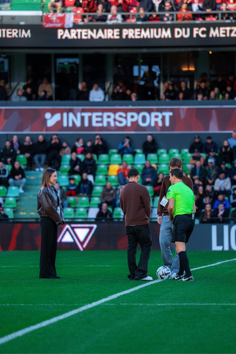 FCMetz's tweet photo. Une image qui vaut mille mots 🥹
Tahirys Dos Santos, sa compagne Coline et Eliot Thelen, passé par le centre de formation grenat, tous les trois rescapés du drame de Crans-Montana, ont donné le coup d’envoi fictif de #FCMSB29 👏 https://t.co/ZvXMYsAT78