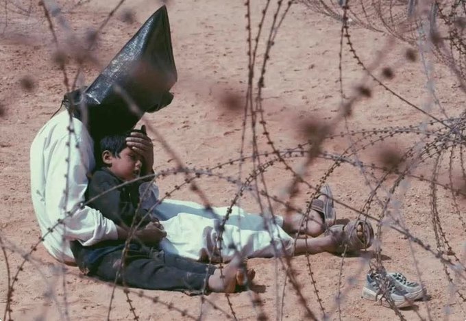 "🇮🇶 Iraqi prisoner of war comforting his 4-year-old son in Najaf, Iraq, March 31, 2003. The photo won the Pulitzer Prize..... 
 
The photograph captures an Iraqi prisoner of war sitting on the ground, his head covered by a black hood, gently placing his hand over his child’s