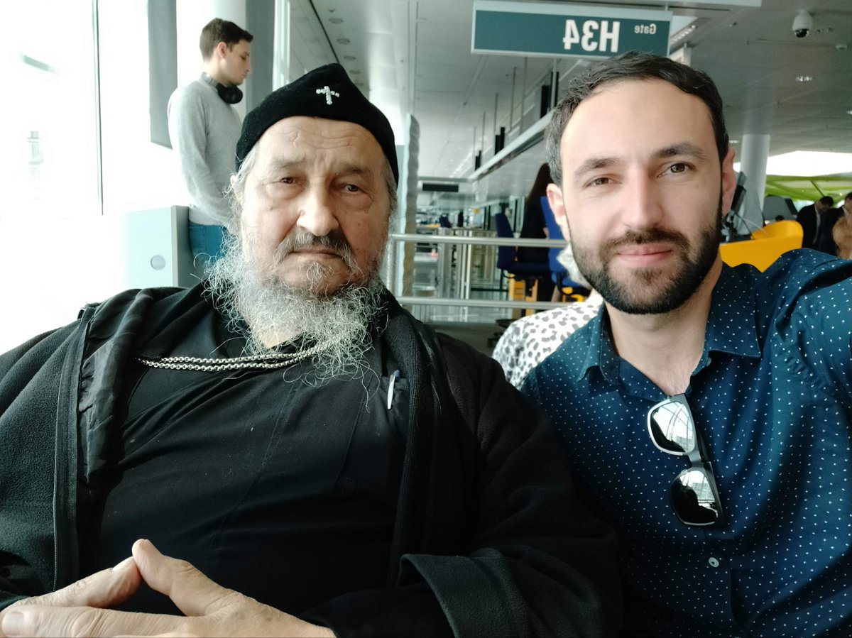 nikolazstankovi's tweet photo. Владика Атанасије нас је учио нечему што наизглед делује једноставно, а заправо је веома тешко – да будемо пажљиви. Често је понављао да је „пажња друго име за љубав“. Да видимо човека поред себе, да чујемо туђу муку, да не прођемо равнодушно поред неправде. У времену грубости и буке, подсећао нас је да се истинска вера и истинско човештво препознају управо у тој тихој, будној пажњи према другоме.

Али нас је учио и нечему другом – храбрости. Храбрости да кажемо истину, да станемо уз слабе, да се не уплашимо моћних. Био је строг, понекад и громовит, али та громовитост није долазила из љутње, већ из срца које није могло да ћути пред неправдом.

Две фотографије које данас објављујем подсећају ме управо на те његове лекције. На једној смо испред капеле у оквиру логора Дахау у Немачкој, месту где је човечанство дотакло своје најмрачније дно. Ту сам још јаче разумео колико је важна она његова опомена да будемо пажљиви према човеку, јер свака равнодушност према другом може постати почетак великог зла.

На другој фотографији смо на аеродрому. Аеродроми су места долазака и одлазака, тренуци између два неба и два пута. Са Владиком Атанасијем сваки пут је деловао као полазак ка нечему већем: ка истини, ка слободи, ка Богу. И зато ми се чини да је он и данас негде на том великом небеском путу, свеприсутан у сећањима и у поукама које нам је оставио.

Зато је његова порука остала једноставна и снажна: будимо пажљиви, јер без пажње нема љубави. И будимо храбри, јер без храбрости нема истине.

На данашњи дан нас је напустио, али оно чему нас је учио остаје као путоказ: да живимо пажљиво према људима и храбро пред истином.