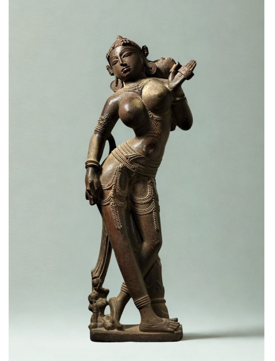 She holds a manuscript.

Not a veil.
Not a pot.
Not a mirror.

A manuscript. 📜

Read that again.

This is not decoration.
This is documentation.

Before “women weren’t educated.”
Before “textual authority was male.”
Before colonial historians decided who was allowed to read,