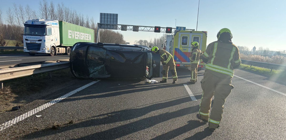 Auto op zijkant op A15 bij Hardinxveld-Giessendam, hulpdiensten ter plaatse