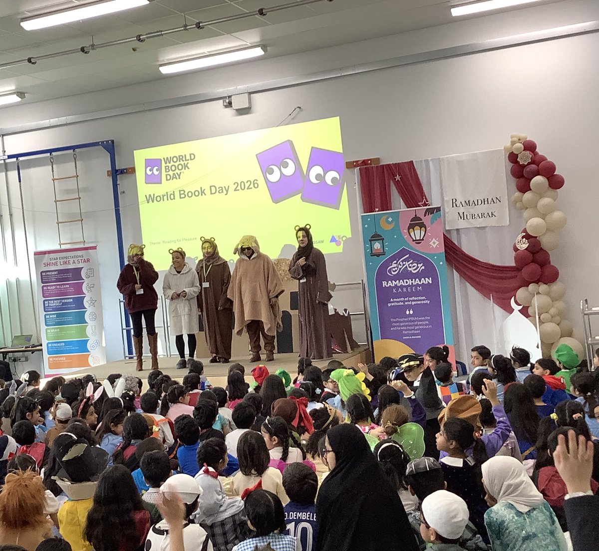 olive__preston's tweet photo. World Book Day 2026 assembly and staff on the stage! Well done to our children for guessing the theme in each year group. #WorldBookDay2026 #BringingLearningToLife #LoveReading #Inspired #Teamwork #Ambition #WeAreSTAR https://t.co/oTjkGzoWu0