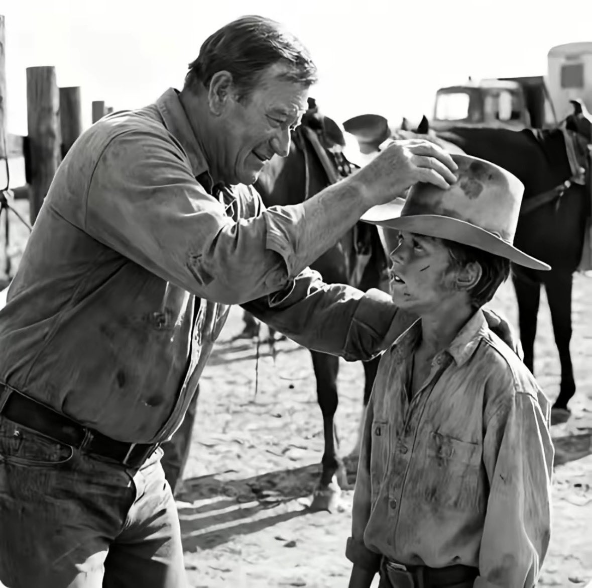 FarmGirlCarrie's tweet photo. What a beautiful story about the legendary “Duke” John Wayne 🤠 

John Wayne Stopped a Hollywood Set Cold - For a 13-Year-Old Boy
Summer 1971. New Mexico.
The set of The Cowboys bakes under a brutal desert sun.

A 13-year-old local ranch boy — hired because he could actually ride — takes a hard fall from his horse. He scrapes his hands. Blood runs down his cheek. His hat is crushed in the dirt.

Instead of asking if he's hurt, the first assistant director explodes.
"You're done. Get off my set."
Fifty crew members watch.
No one speaks.
Except one man.

John Wayne rises from the shade of his trailer and walks across the dust.
Anyone who worked with him knew that walk - slow, deliberate, boots heavy against the earth. He didn't rush toward trouble. Trouble waited for him.

He stops three feet behind the assistant director.
"You don't run this set, mister," Wayne says quietly.
"I chose that boy."

No shouting.
No theatrics.
Just authority.
The assistant director says nothing.
Wayne turns his back on him — the ultimate dismissal — and walks straight to the boy.

And this is what the crew never forgot.
The anger vanishes from Wayne's face. Instantly.
He pulls the boy in close, tucks him under his arm
— protective, fatherly — shielding him from every eye on that lot.

"You took a hard fall, son," Wayne says.
The boy nods.
"You know what a real cowboy does when he falls off?"
The boy looks up.
"Gets back on, sir."
Wayne smiles.
"That's right."
He picks up the crushed hat, dusts it off himself,

Then he turns to the crew.
"Reset!"
That was it.
No speech about respect.
No lecture on decency.
Just a quiet line drawn in the sand.
The boy stayed.
Finished the film.

And decades later, he still kept something that belonged to John Wayne — not just a memory, but the moment a legend chose to stand beside him when no one else would.

Because sometimes courage isn't in the script. It's in what you do when a kid is humiliated and fifty adults stay silent.
That day, the Duke didn't just play a cowboy.

He proved he was one. 

The End 🤠