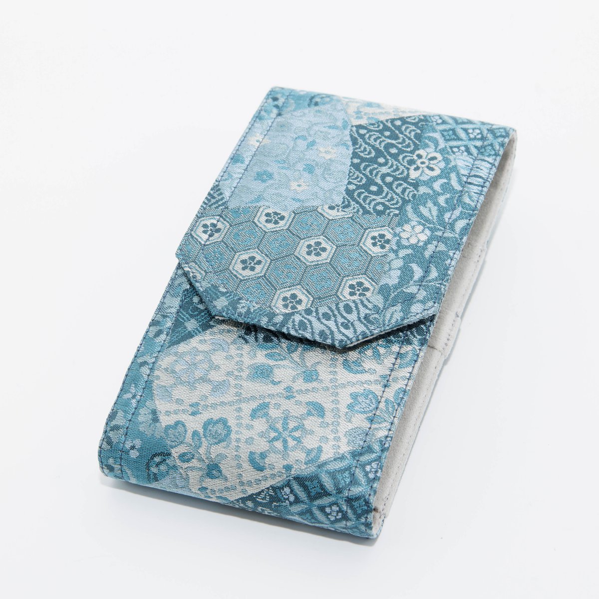 BUNGUBOX x yurie の新商品、
フラップタイプのペンケース3本入れが登場しました！
京都の老舗 誉勘(こんかん)商店謹製の西陣織で
万華鏡（カレイドスコープ）のような幾何学模様が
青色基調で織り込まれた生地を採用しました！
ブルーのカレイドスケープ が見せる一期一会の美しさが