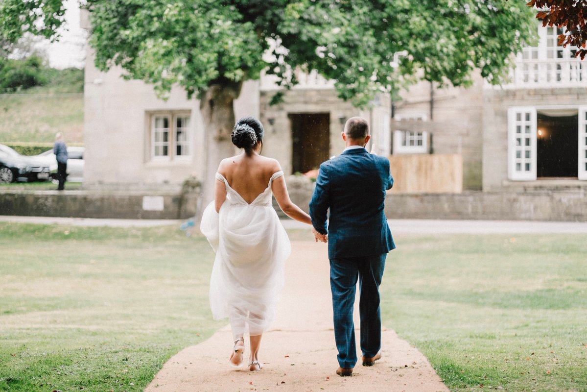 The ceremony concludes and the couple step away together, heading across the grounds toward the house and cave bar where the reception awaits. Guests follow behind, moving through the same spaces that framed the vows as the celebration continues.