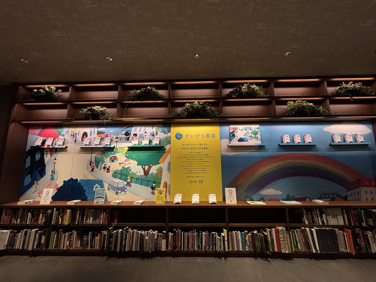 kaigarabooks's tweet photo. 明日オープンのかいがら書店ですが、会場のセッティングが完了しました

ショートショートの作中に出てくる「虹みがき」を模した大きな虹の絵が目印です🌈
今はくすんでいますが、参加者の皆さまにシールを剥がしていただくと、綺麗な虹が徐々に完成していきます。

向かって左側の絵は、大桃洋祐さんに手がけていただいたショートショートのカバー絵です。
こちらには剥がしたシールの裏に書かれたお金に関する問いかけへの回答を貼り付けていきます💰
他のみんなの答えも見てみよう！
詳細はコチラ▶https://t.co/zKoJt7wkyJ