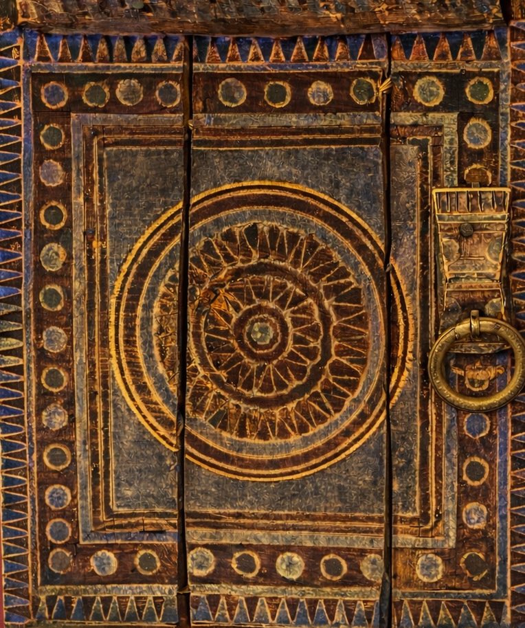 هذه الزخرفة تمثل نموذجًا مميزًا من الفن النجدي، حيث يعتمد على الهندسة البسيطة المتكررة (دوائر، مثلثات، مربعات) لتكوين باب يحمل قيمة جمالية وتراثية، ويعكس مهارة الحرفي النجدي في تحويل العناصر  إلى عمل فني غني بالرمزية 
والمثلثات يطلق عليها (سنون )ترمز  إلى الجبال أو القوة والحماية