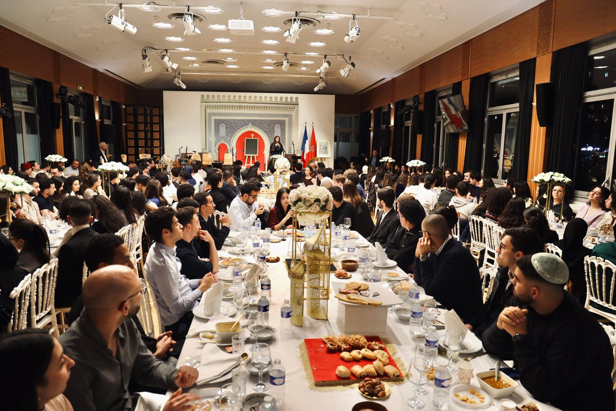 AmbaMarocFrance's tweet photo. Magnifique et indispensable message de #Paix et d'unité diffusé par les 250 étudiants #marocains réunis autour d'un #ftour organisé par l'Ambassade du #Maroc 🇲🇦 en #France 🇫🇷.
#Musulmans, #Juifs et leurs invités #chrétiens ont partagé à la Maison du Maroc, notamment avec l'Ambassadeure Samira #Sitaïl, un moment précieux de #fraternité et véhiculé des valeurs de partage, de respect et de soutien mutuel autour du drapeau national. #Ramadan_2026
#RamadanKareem